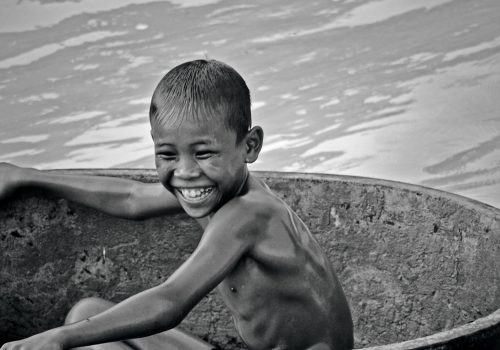 Boy on self-made ship in the pond